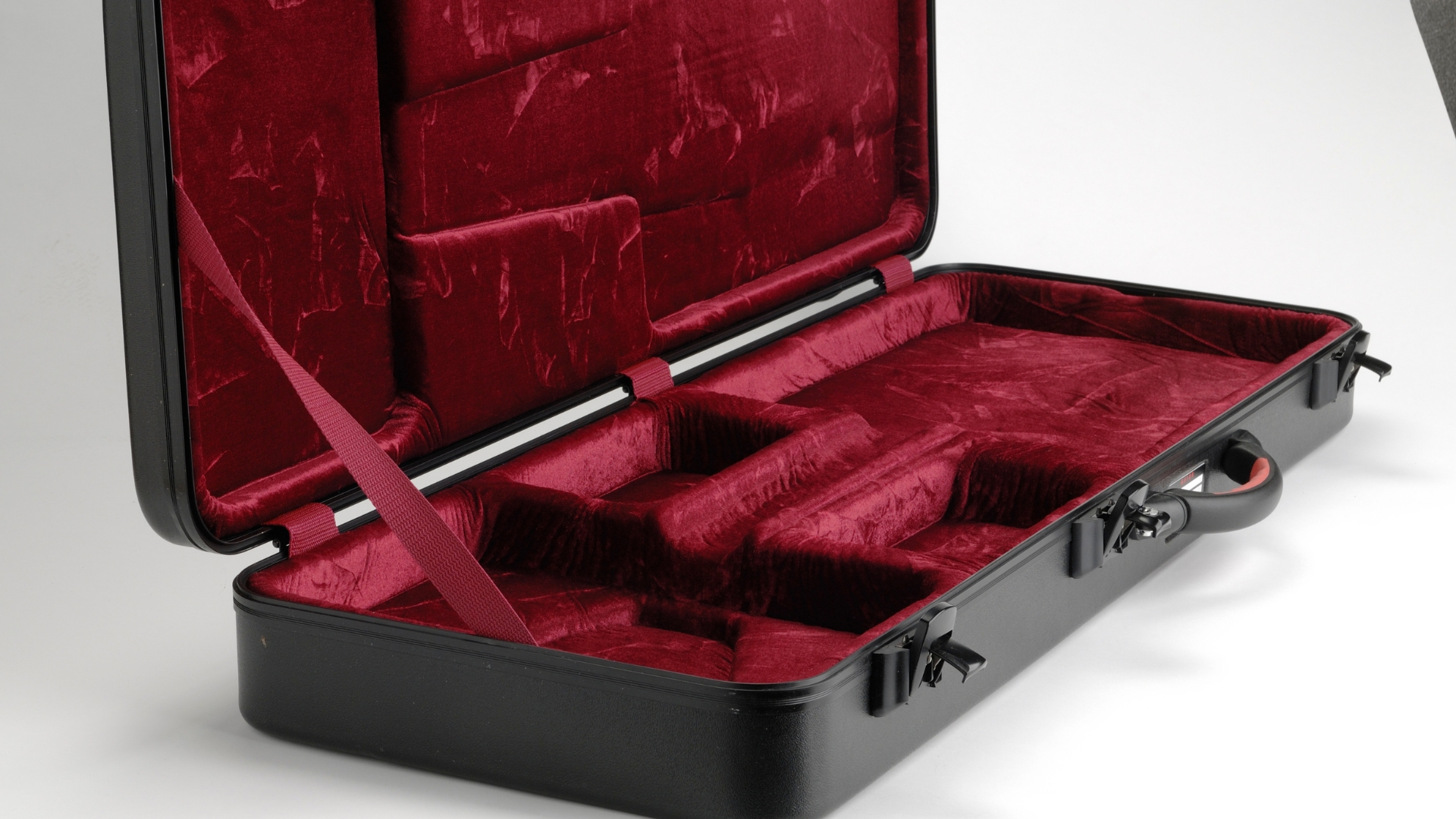 An empty guitar case open on the floor