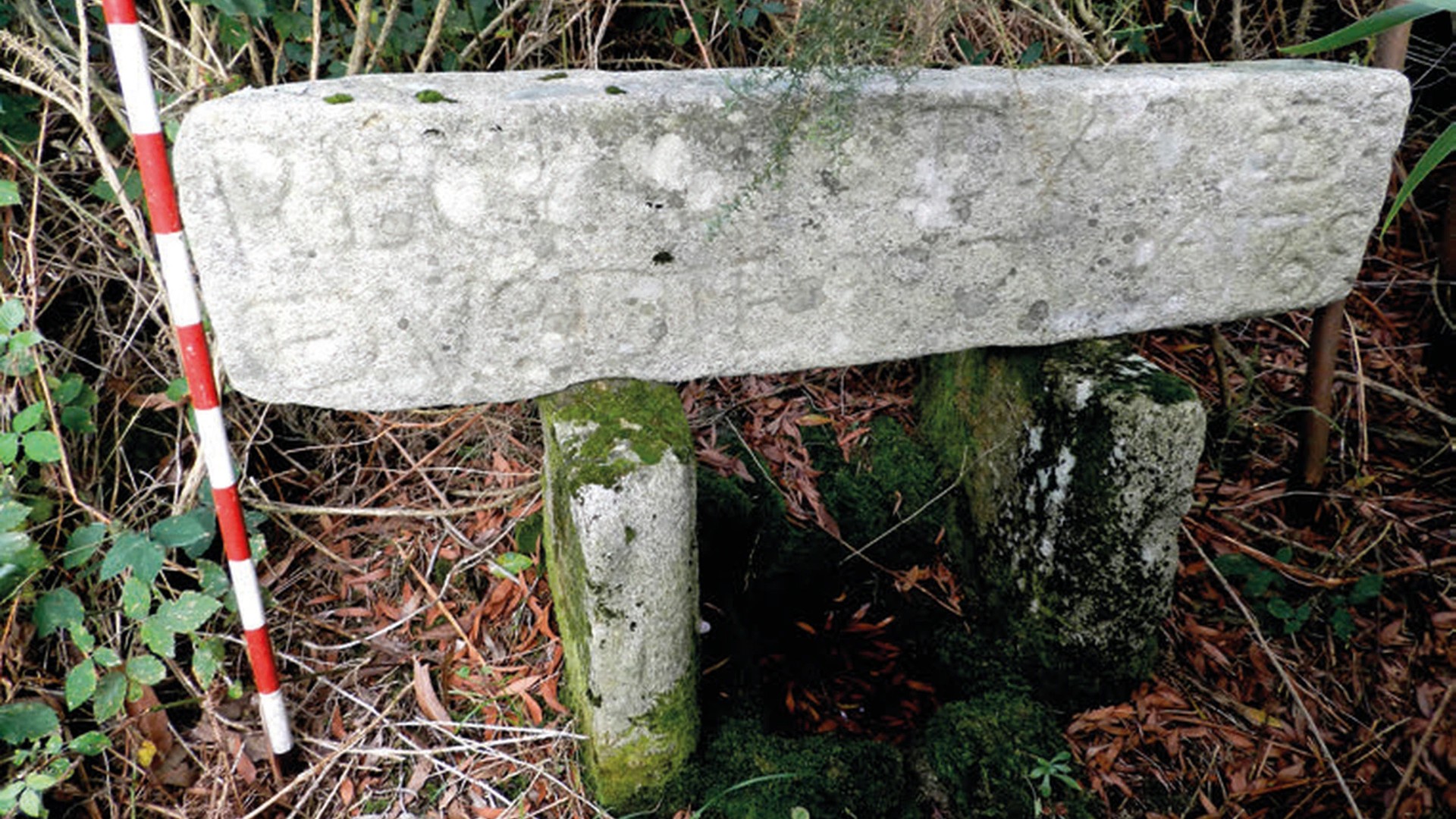 Aquí vemos un letrero grabado en piedra sobre dos soportes de piedra más pequeños.