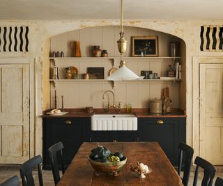 A classic English farmhouse style kitchen with a sink/utility built into an alcove which is an original feature of the room