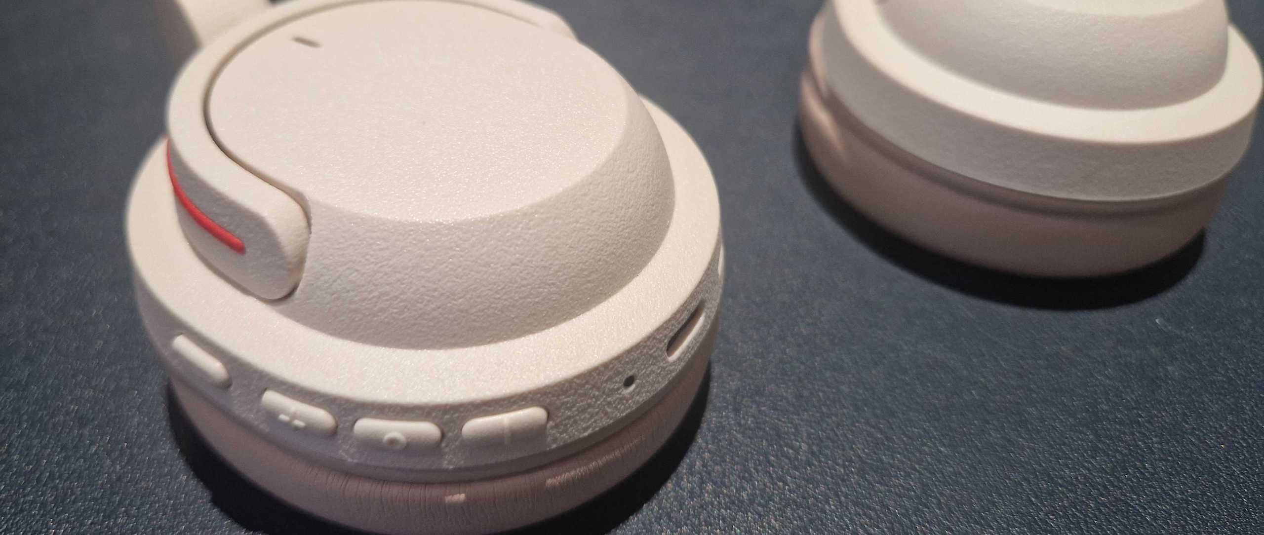 An off-white pair of BonoBeats Lite headphones sitting on a table