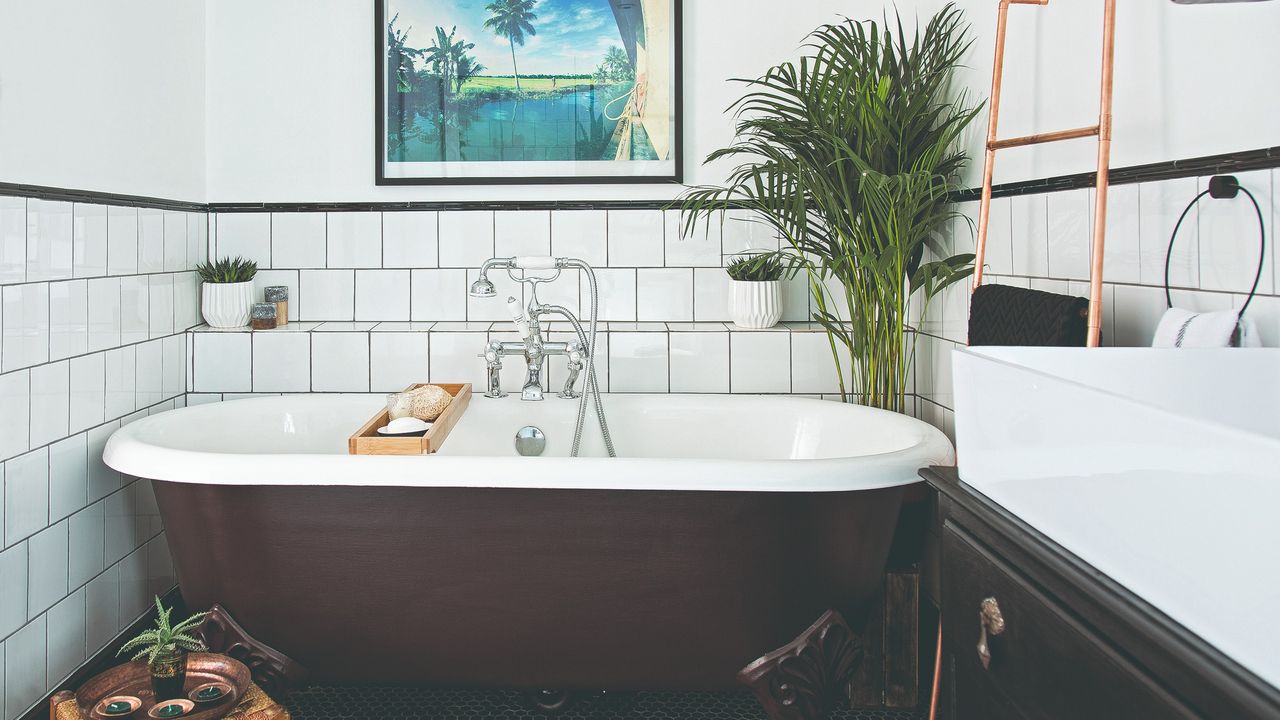 A white-tiled bathroom with a brown free-standing bathtub