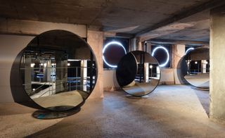 Exhibition by Selfridges that features a concrete maze of darkened rooms