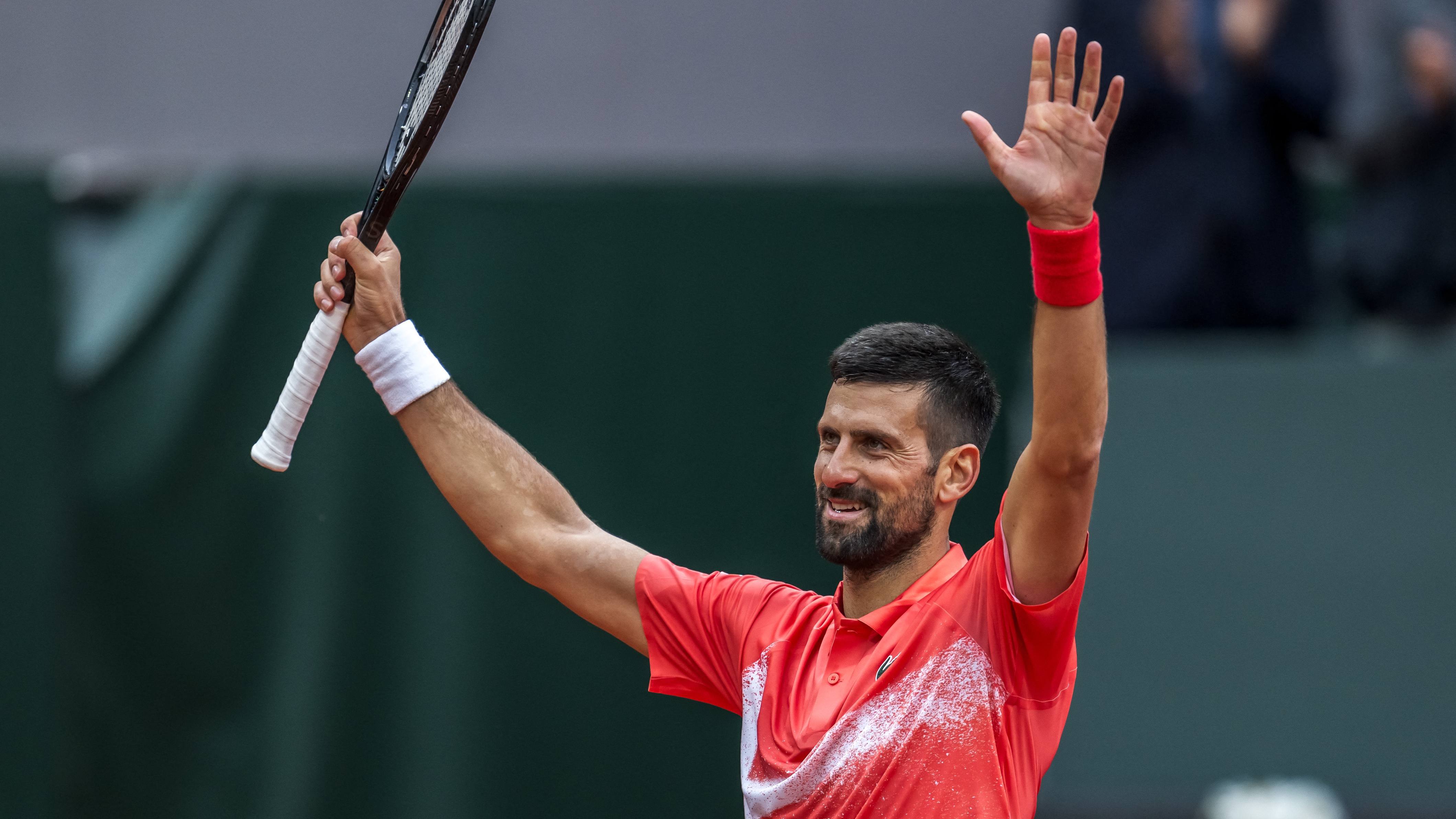 Novak Djokovic raises his racket after winning at the Swiss Open.