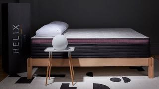 2024's best mattress for stomach sleepers is the Helix Dusk Luxe Mattress, shown here on a wooden bed in a dark bedroom