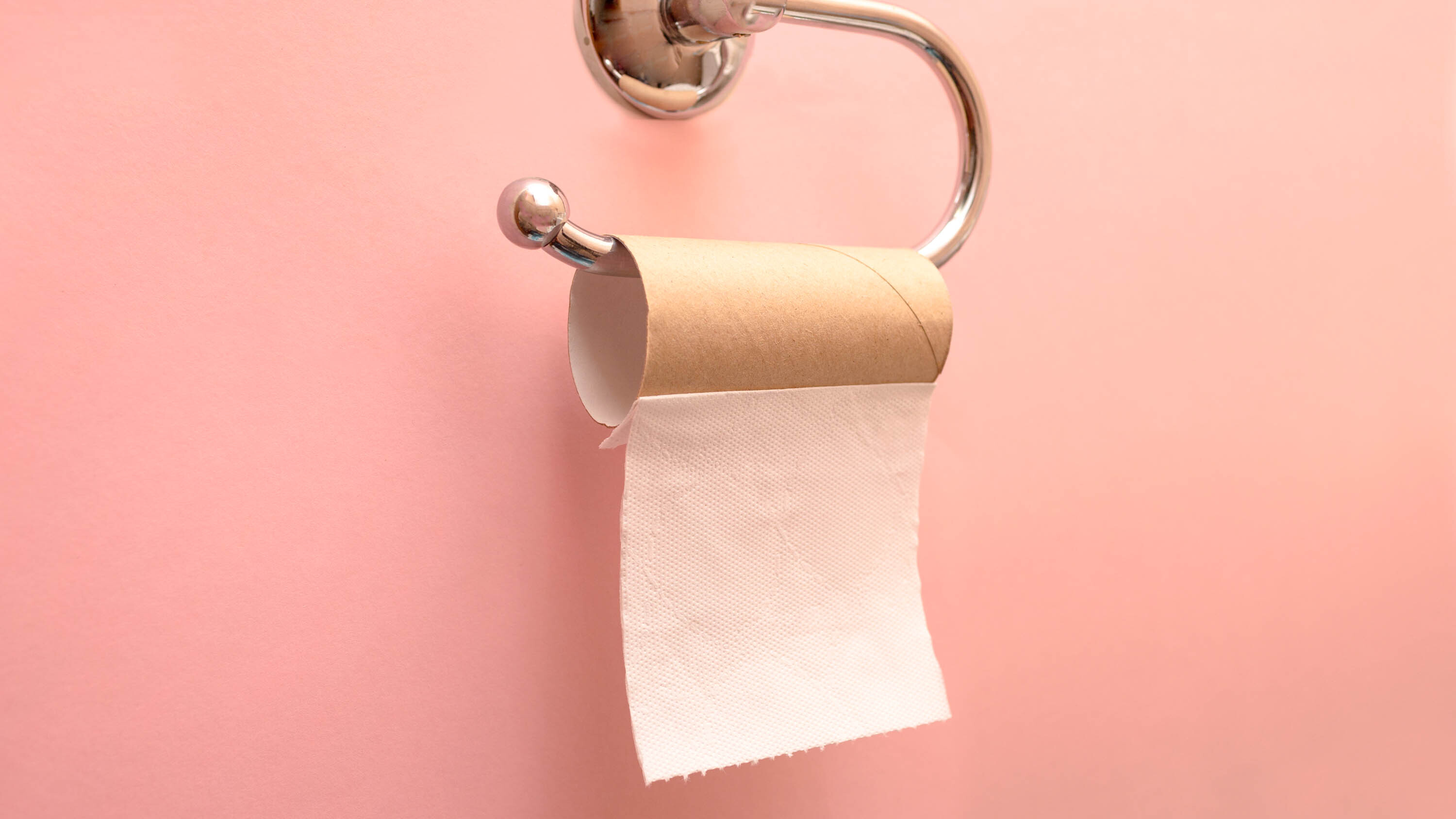 A roll of toilet paper hanging on a holder with only one square left