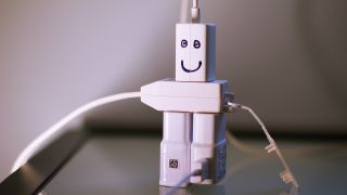 A robot made out of chargers plugged together, with a smiley face