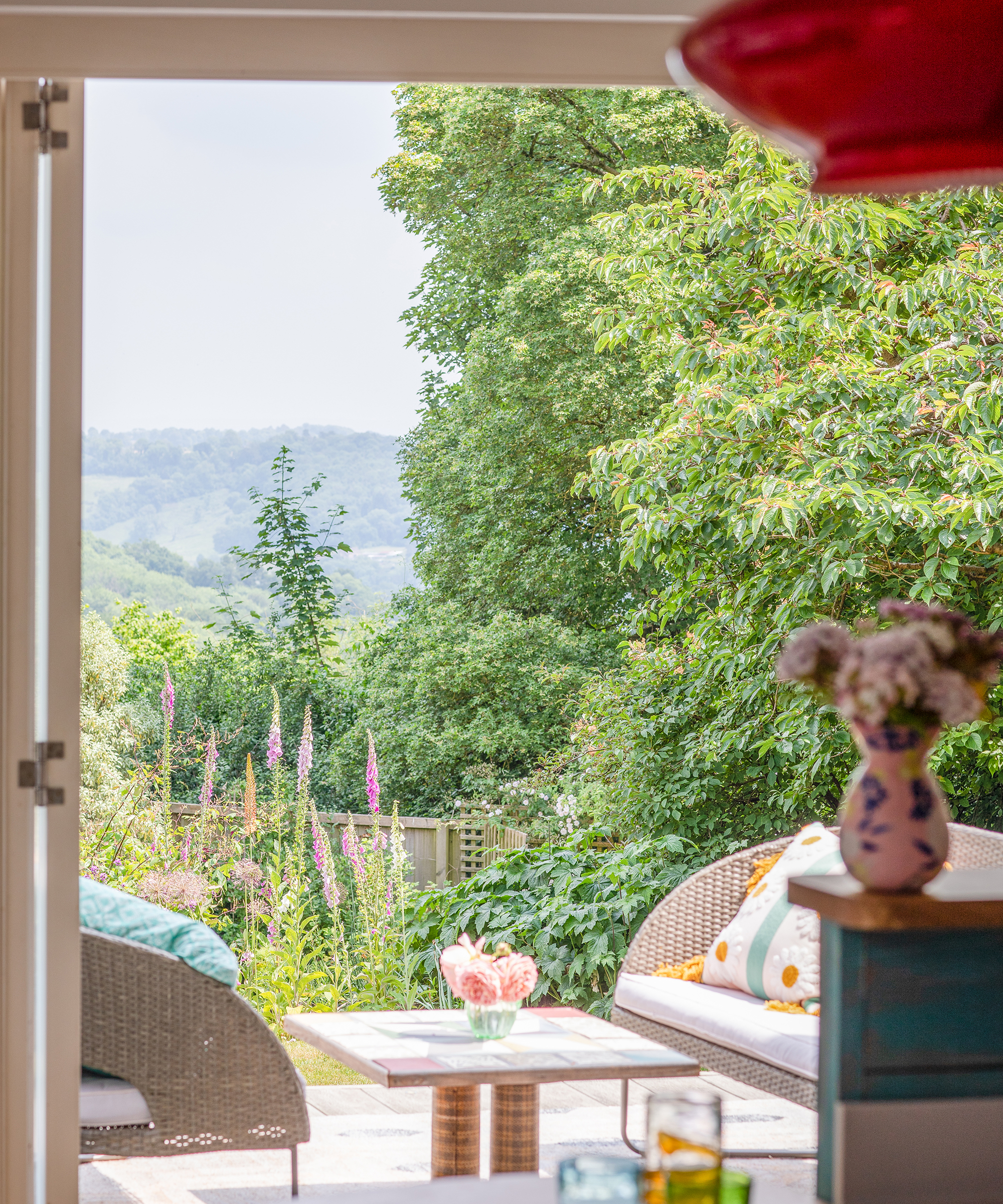 View out from a room onto a decking area with countryside view beyond