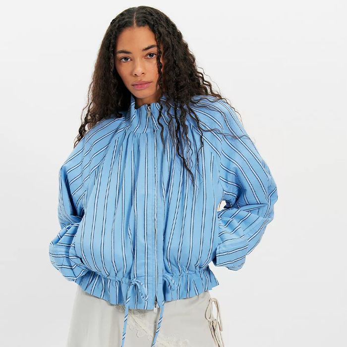 Models wear Free People clothing. One wears blue striped jacket and jeans while the other model is wearing a tom boy like outfit. 