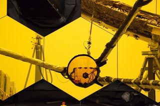 During a test of NASA's new James Webb Space Telescope, an engineer snapped this photo of the telescope's enormous primary mirror reflector off its smaller secondary mirror. If you look closely, you can see part of the secondary mirror reflecting off the gold panels that make up the telescope's primary mirror. This photo was taken while NASA engineers were performing a test run of the mechanism that deploys the secondary mirror's support structure.