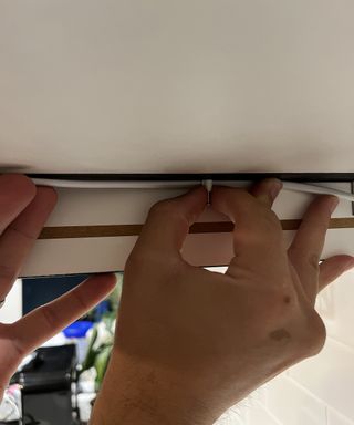 Hand tacking wire to underside of a cupboard