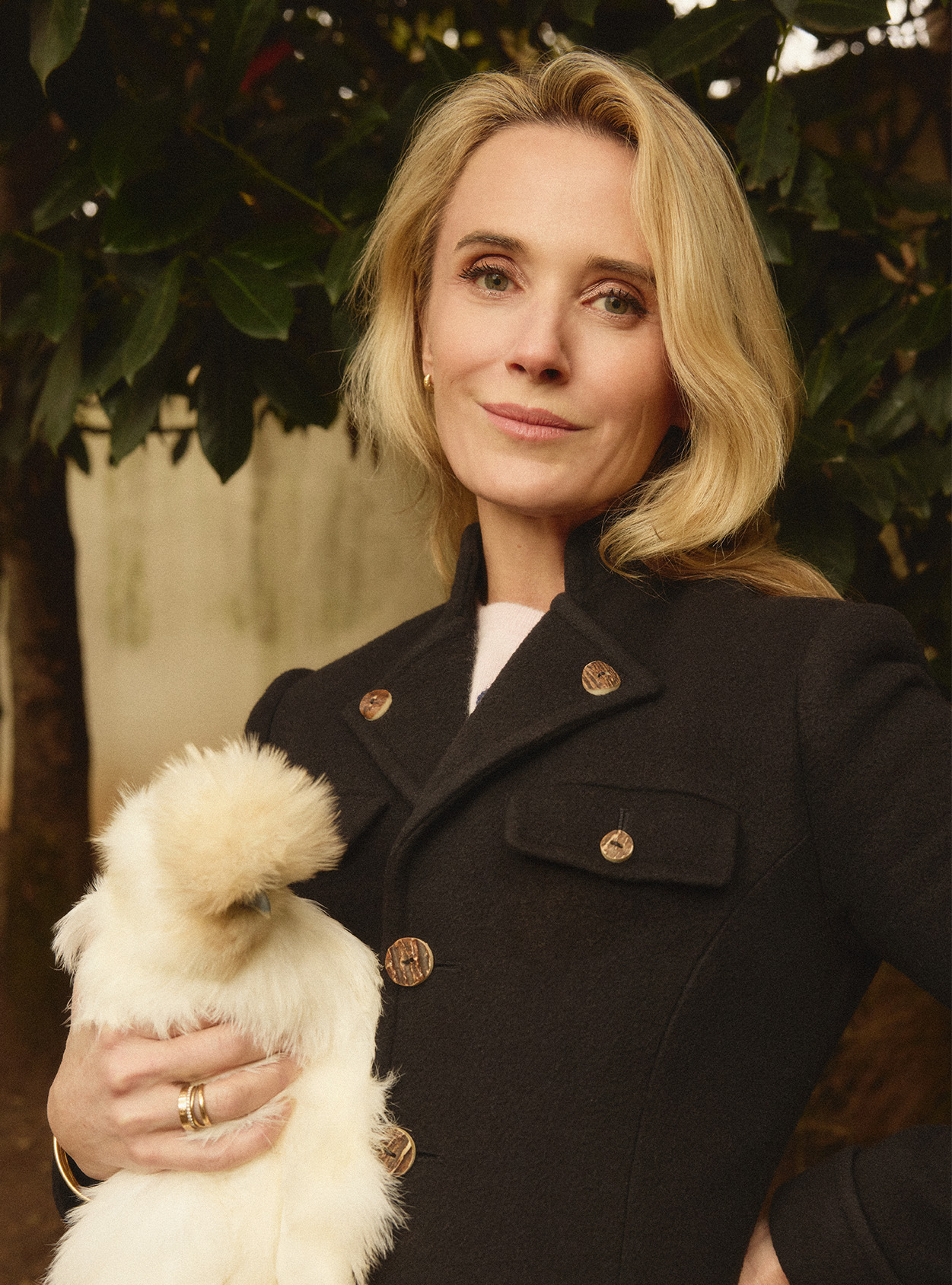 Jennifer Siebel Newsom holding a white chicken outside
