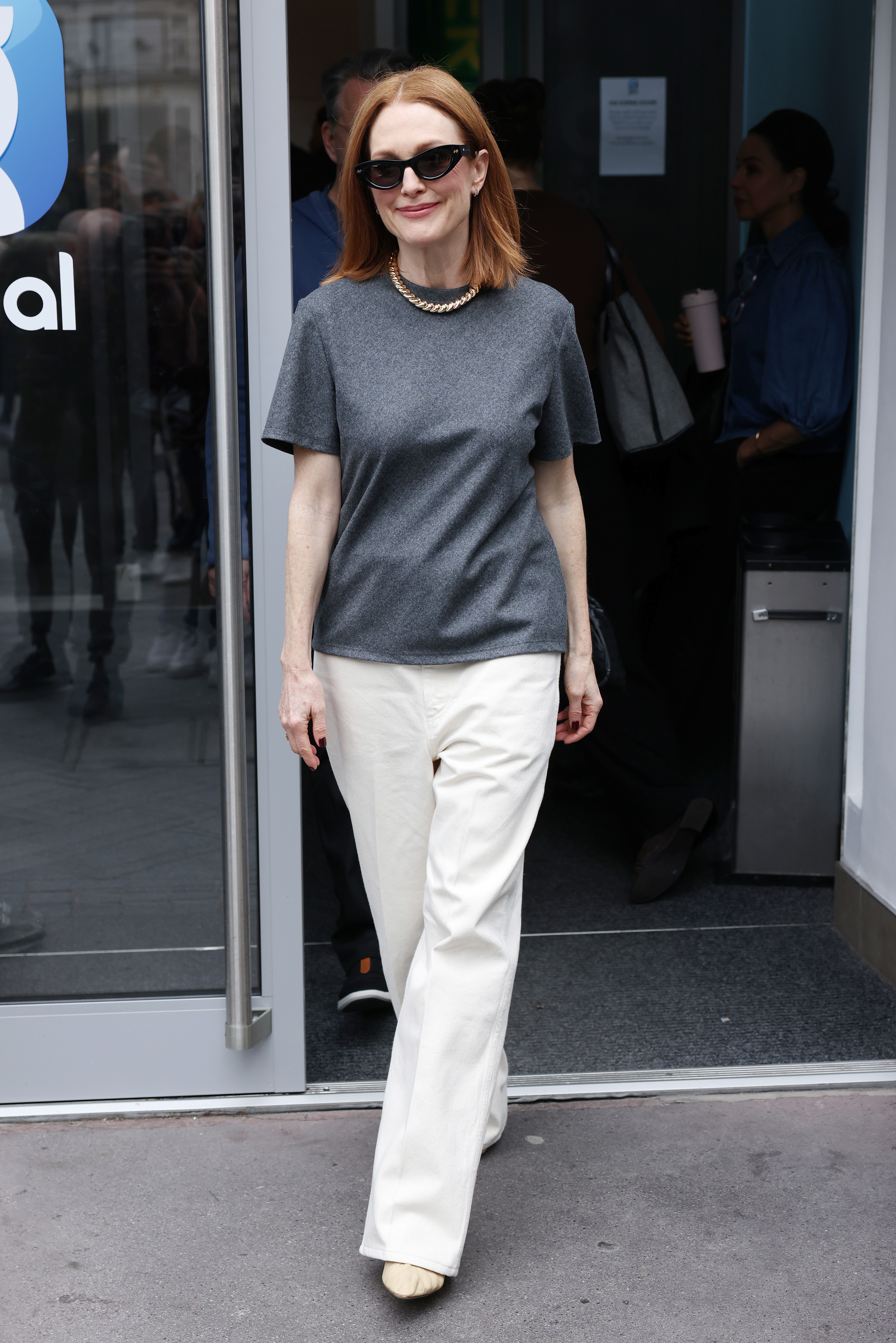 Julianne Moore wears a gray t-shirt, white jeans, and black sunglasses.