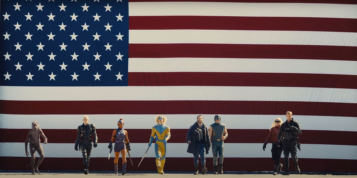 The Suicide Squad group shot in front of a flag