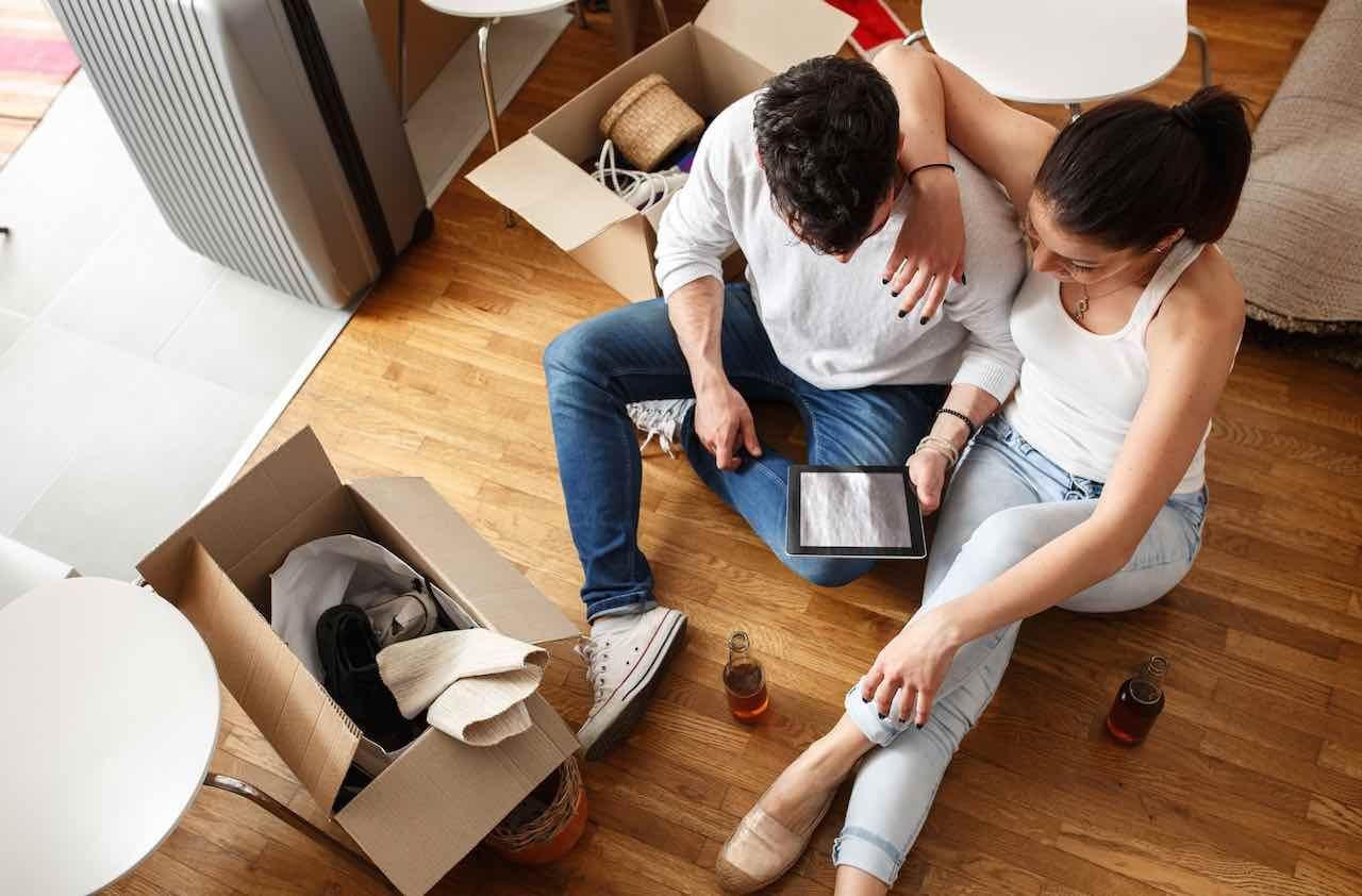 Young couple Moving in new home.Sitting on floor and relaxing after cleaning and unpacking.