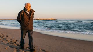 Older man walking along the beach