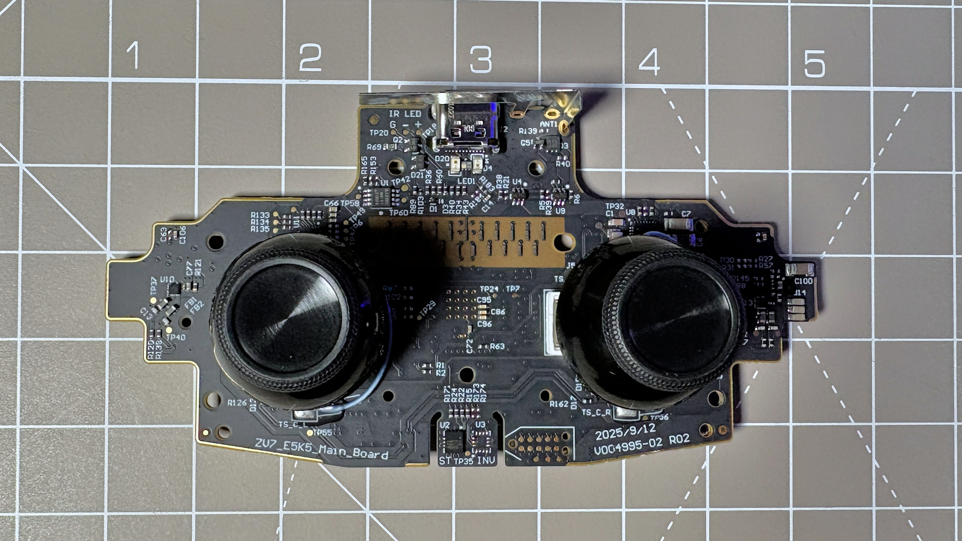 The Steam Controller on a desk during a teardown, with various parts removed.