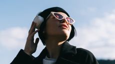 Woman wearing headphones and looking up at the sky