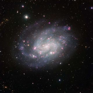 Spiral Galaxy Like Our Own Shines With Pink Clouds