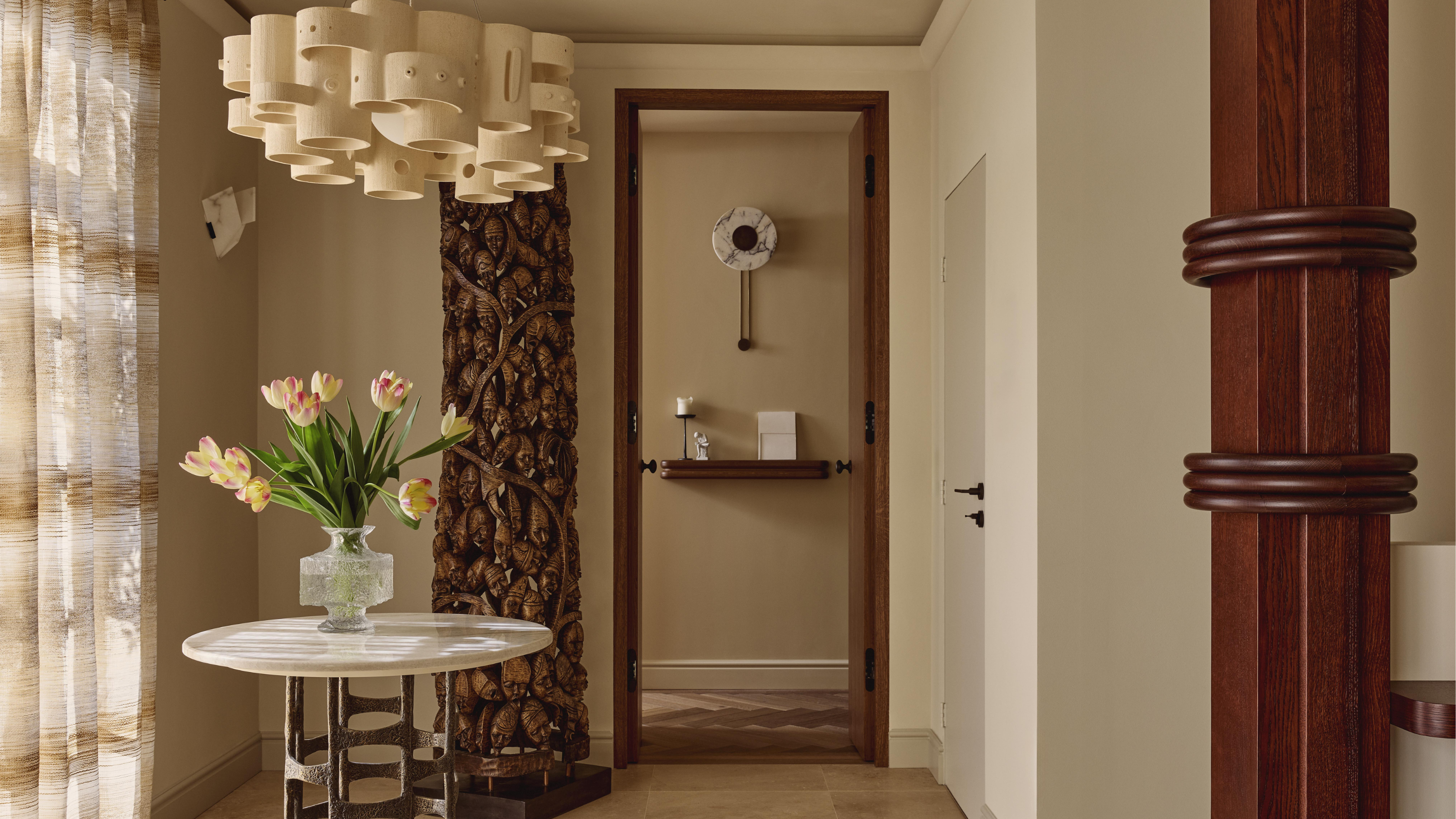 Entryway with table, wood sculpture and bespoke column wrapped in walnut timber