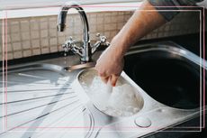 A close up of a person cleaning a kitchen sink