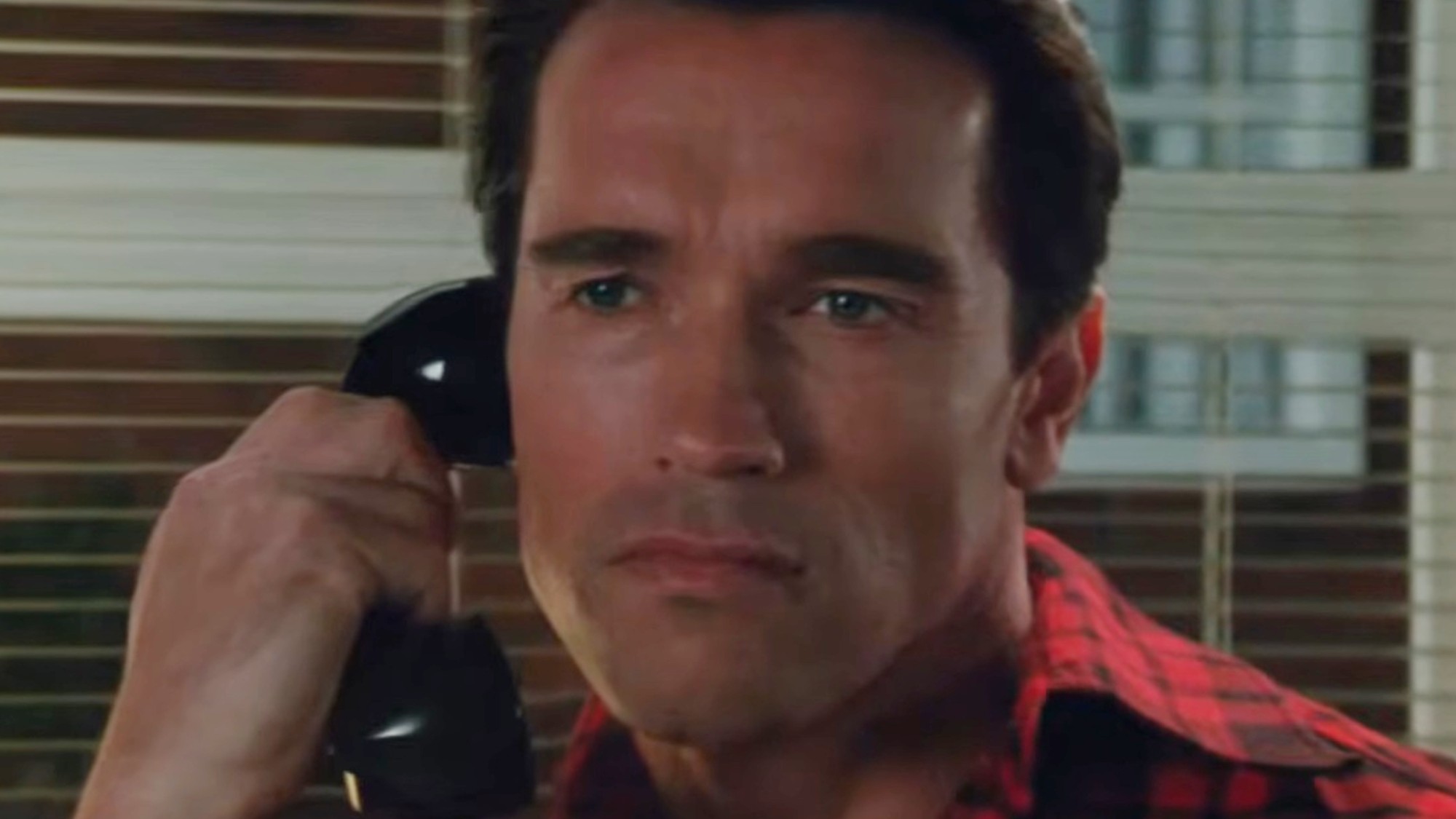 Arnold Schwarzenegger talking on the phone in Raw Deal