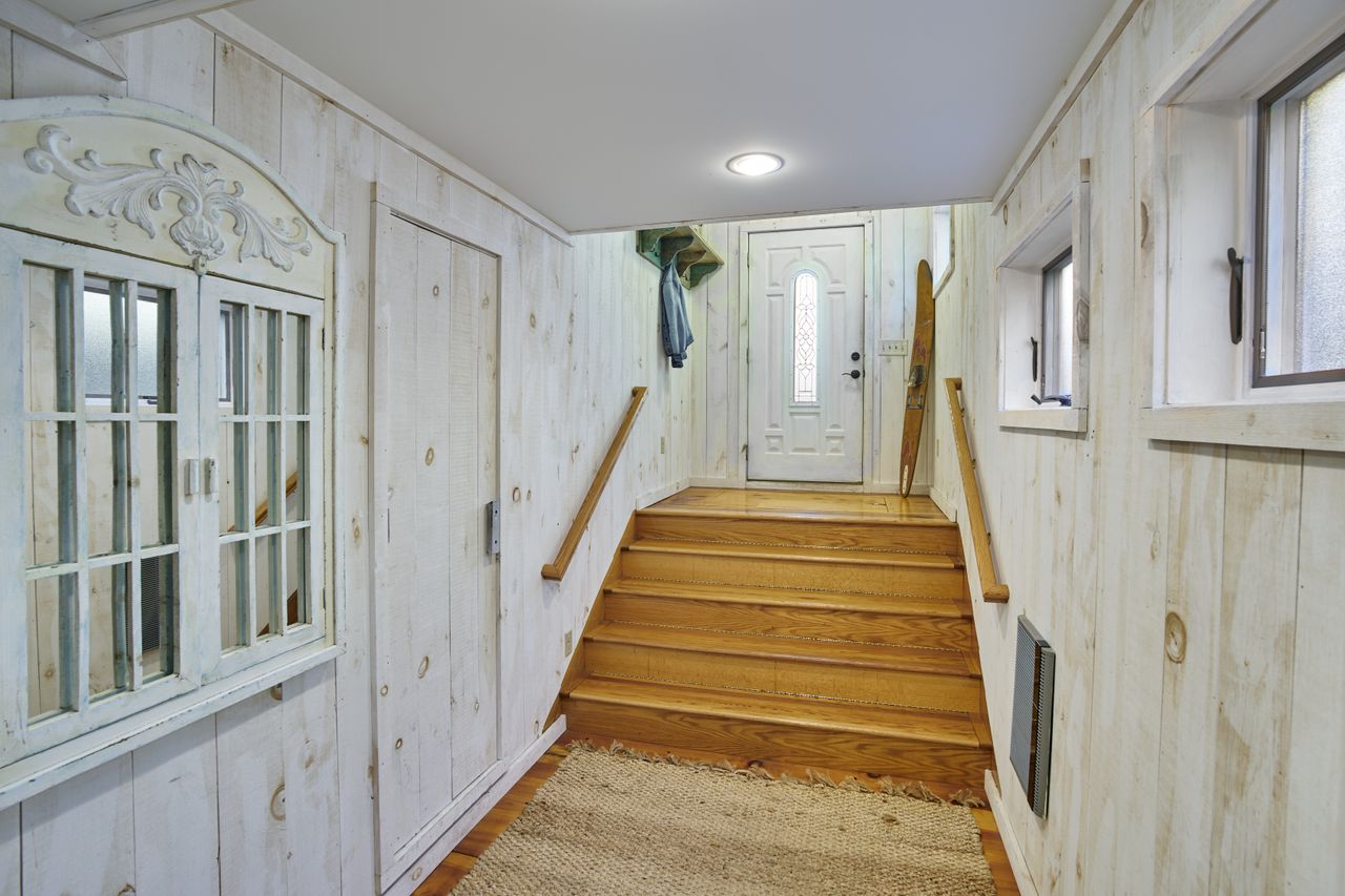 An entryway with white walls and wooden steps