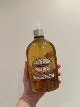 Mica Ricketts holding L’Occitane Almond Shower Oil