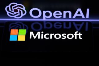 Microsoft logo pictured on a smartphone with OpenAI logo and branding in the background on a computer screen.