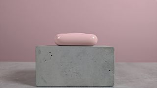 Side view of VRURC T6S power bank on plinth on desk with pink background