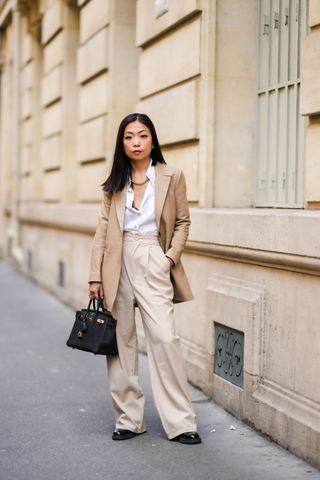 woman wearing a blazer, button-down shirt, trousers