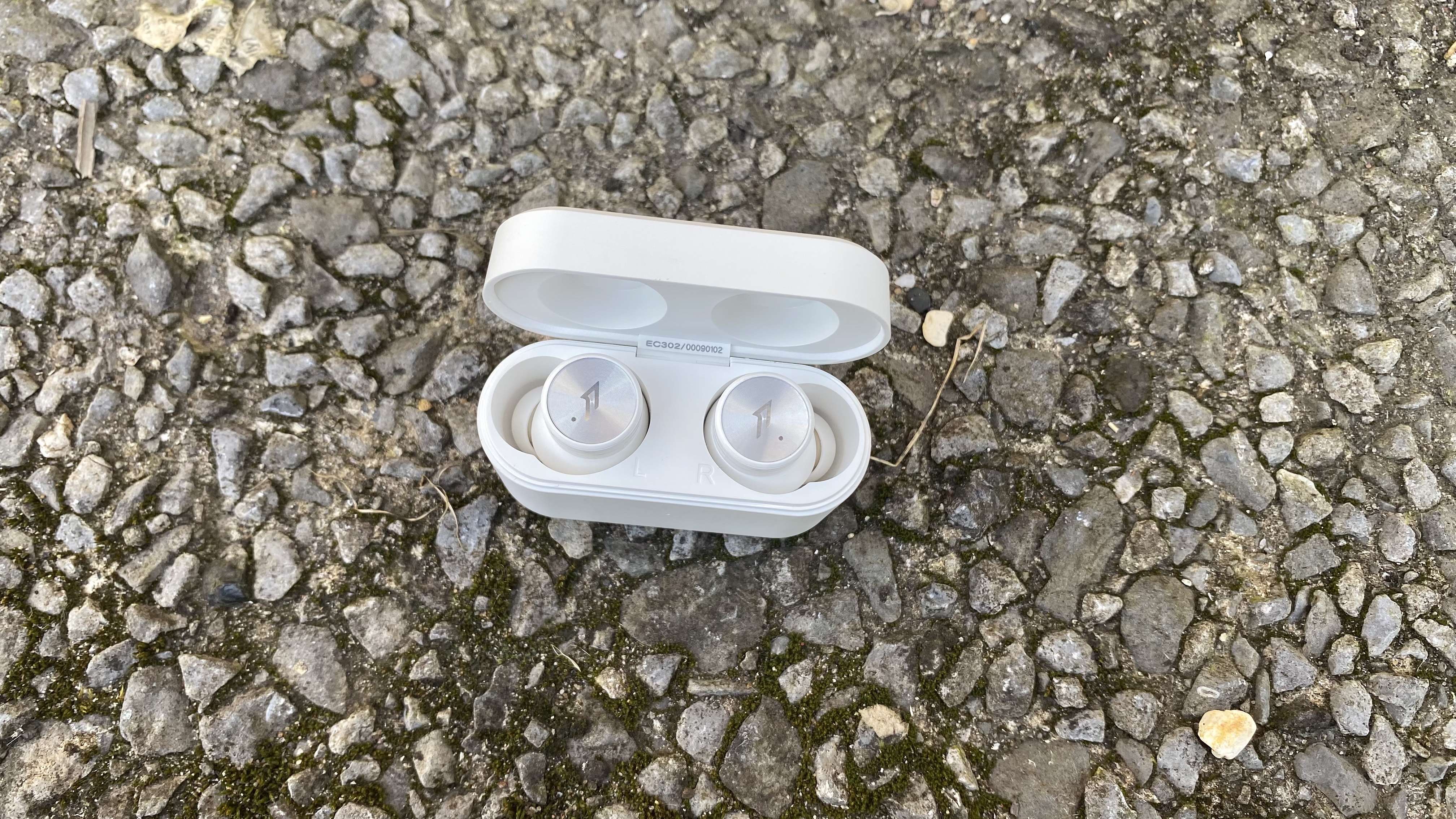 the 1more pistonbuds pro true wireless earbuds in their charging case