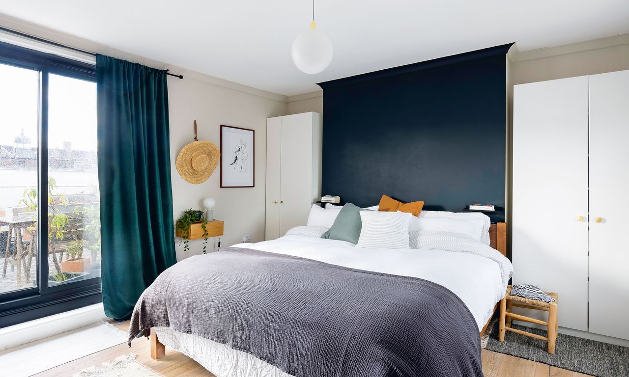 grey bedroom with white bedding, globe pendant light and grey throw