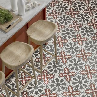 Patterned floor tiles in an orange kitchen