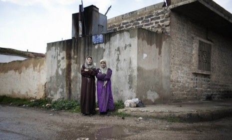 Two women in a besieged town near Homs: Amid Syrian President Bashar al-Assad&amp;#039;s attacks, the country is falling into deep financial strain.