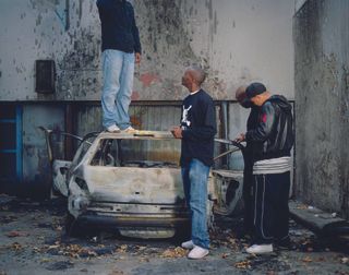 Youths and burnt-out car