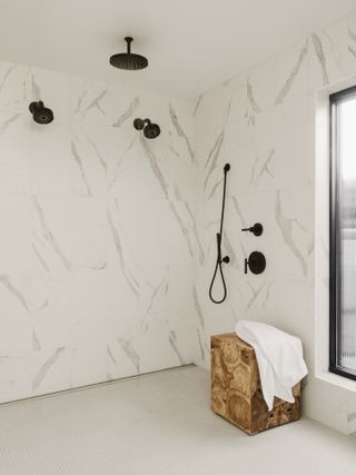 marble style shower room with black fixtures and fittings, wooden stool