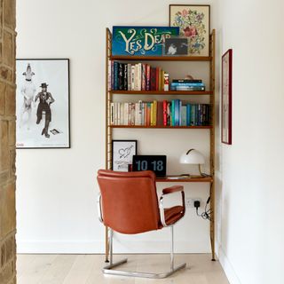 A shelf desk with built-in storage paired with a brown leather and chrome chair