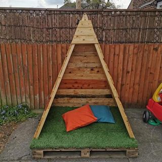 garden area with wooden teepee and cushions