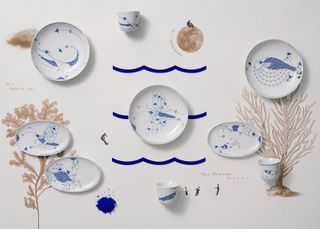 A range of plates, bowls and cups with blue animals and insects on white crockery