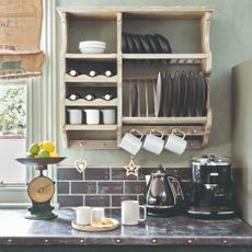 A green-painted kitchen with a black coffee machine and kettle