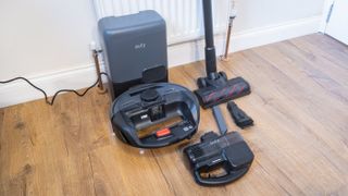 Eufy E20 robovac in dock, with handheld vacuum, floor wand and other accessories next to it