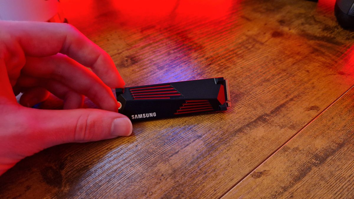 Samsung 990 Pro with a heatsink being held by a reviewer