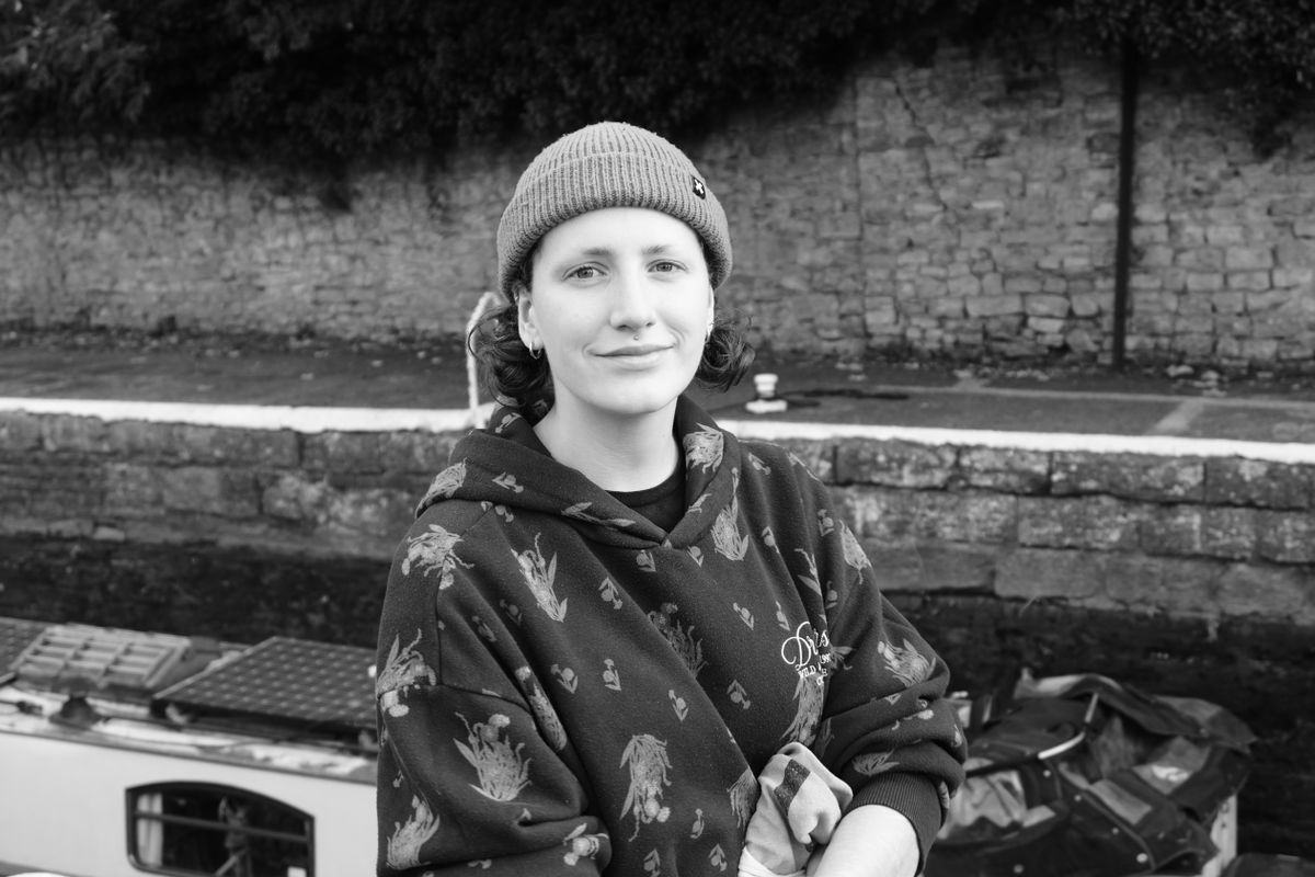 A photo of a woman wearing a hoodie and a beanie, taken on a Sony ZV-E10 II vlogging camera