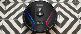 The Eufy RoboVac X8 on a black and white chevron patterned floor
