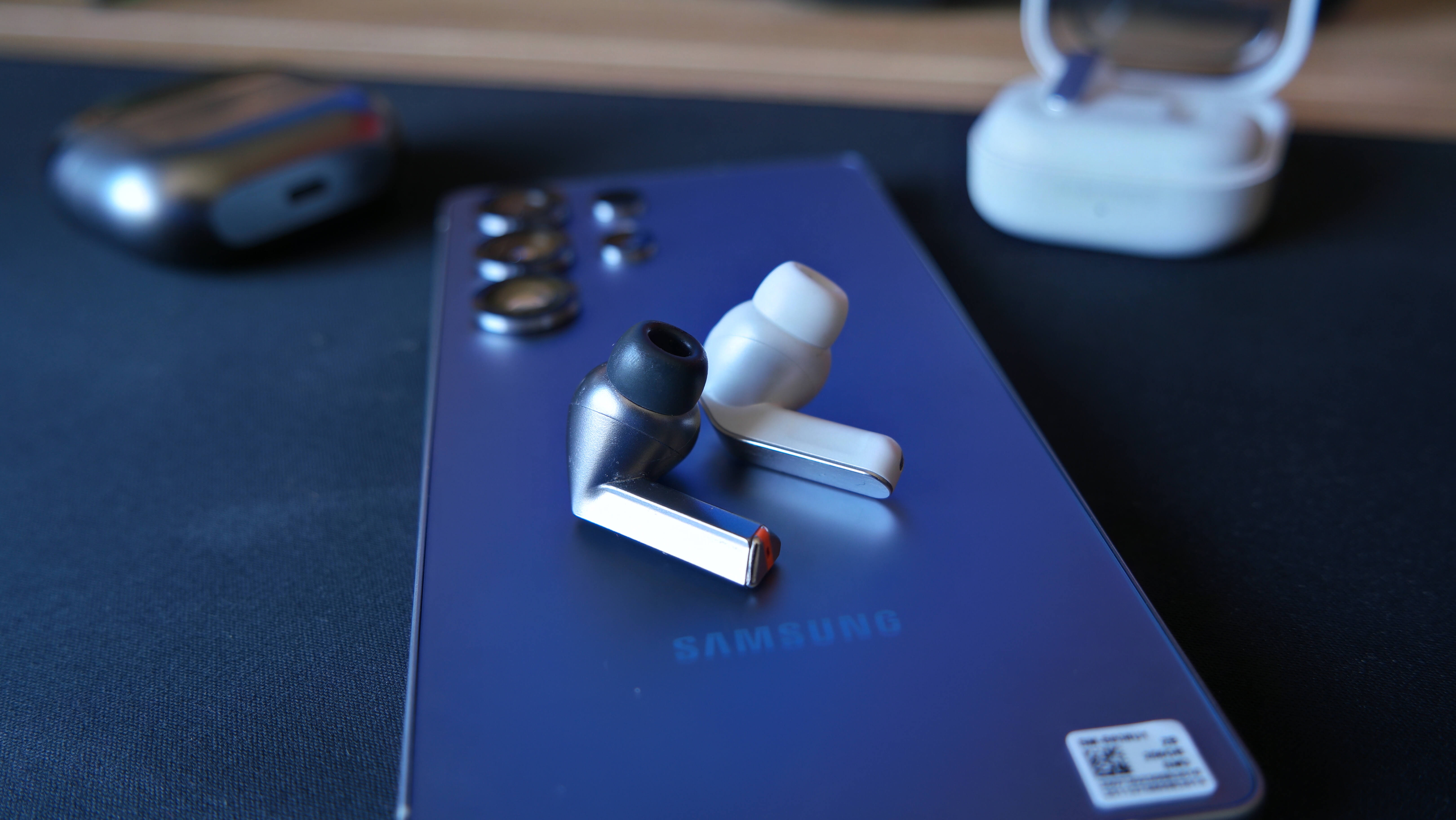Galaxy Buds 4 Pro on a desk, next to Galaxy Buds3 Pro