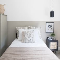 Grey bedroom with white bedding and black bedside table
