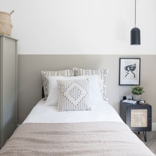 Grey bedroom with white bedding and black bedside table