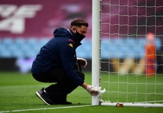 Goal posts are wiped clean with a disinfectant wipe ahead of the match at Villa Park
