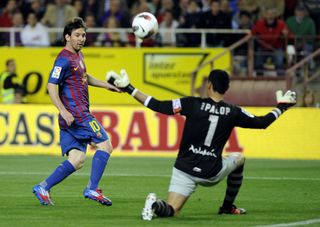 Lionel Messi scoops the ball over Andres Palop to score for Barcelona against Sevilla in 2012.