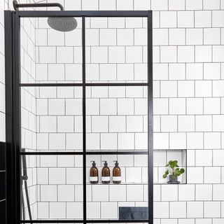 bathroom with white tile wall and glass door